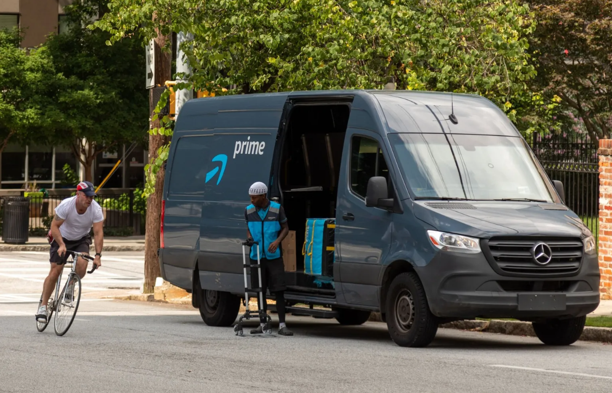 A bike rides past an Amazon delivery van.